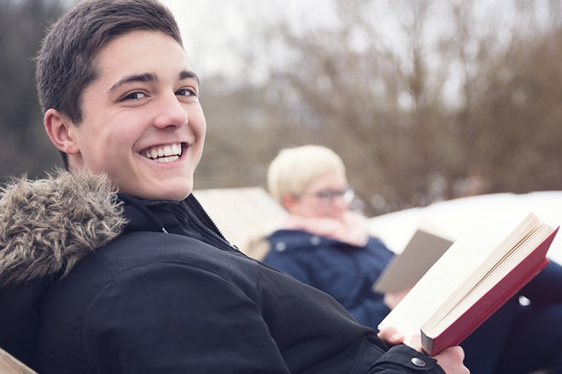 A young man smiles after reviewing his dental insurance plan.